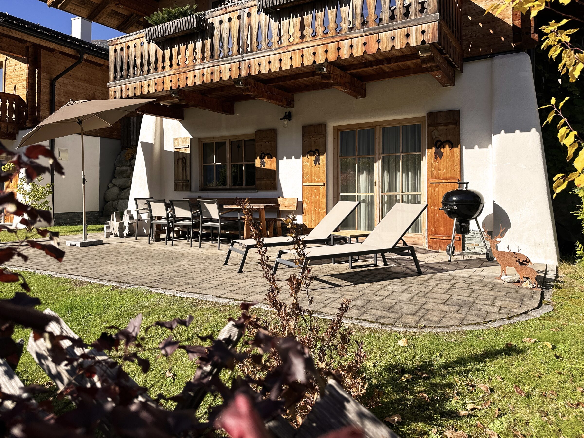 Sonnenterrasse mit Grill und Liegestühlen